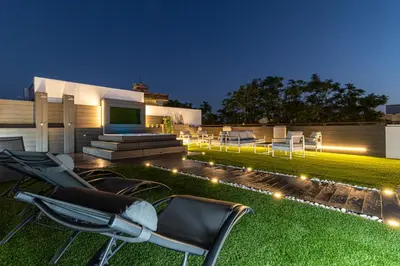 a backyard with chairs and lights on the grass at Allo Apartments Plateros Centro Jacuzzi Comunitario in Jerez de la Frontera