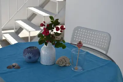 a blue table with a vase with flowers on it at Villa Buganvillas, relax con piscina privada a pocos minutos de la Barrosa y Santi Petri in Chiclana de la Frontera