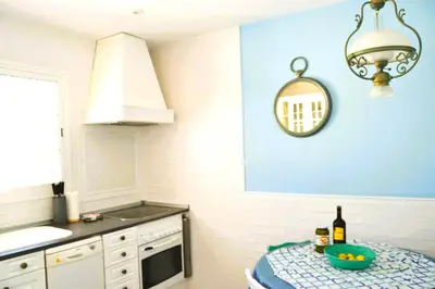 a kitchen with a table with a bowl of fruit on it at Villa Buganvillas, relax con piscina privada a pocos minutos de la Barrosa y Santi Petri in Chiclana de la Frontera