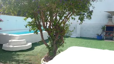 a tree in a yard next to a pool at Villa Buganvillas, relax con piscina privada a pocos minutos de la Barrosa y Santi Petri in Chiclana de la Frontera