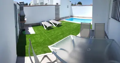 a view of a yard with chairs and a swimming pool at Casa Los Naranjos 3 in Cádiz