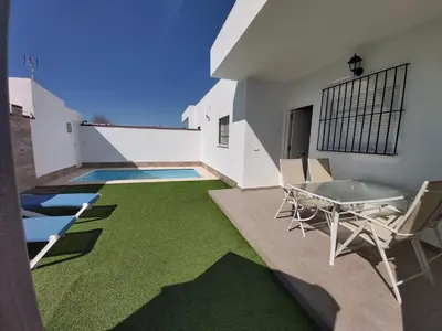 a patio with green carpeting and a table and chairs at Casa Los Naranjos 3 in Cádiz