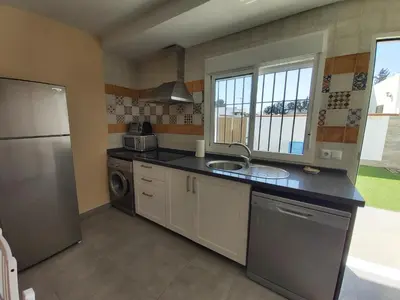 a kitchen with a sink and a refrigerator at Casa Los Naranjos 3 in Cádiz