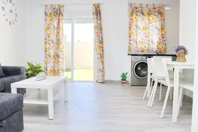 a living room with a table and a washing machine at Chalet del Sultan in Conil de la Frontera