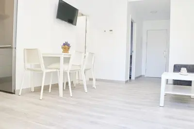 a dining room with a white table and chairs at Chalet del Sultan in Conil de la Frontera
