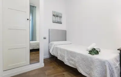 a white room with a bed and a mirror at Doña Blanca Centro Diseño Minimalista in Jerez de la Frontera