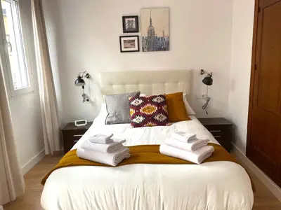 a bedroom with a bed with two towels on it at La Galería de Botica in Cádiz