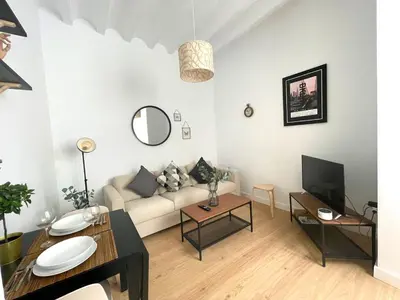 a living room with a white couch and a table at La Galería de Botica in Cádiz
