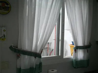 two curtains in a bathroom with a window at Primera línea de playa casita adosada in Chiclana de la Frontera