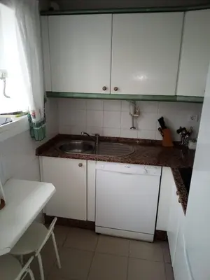a kitchen with white cabinets and a sink at Primera línea de playa casita adosada in Chiclana de la Frontera