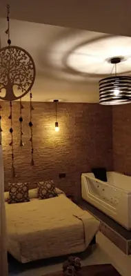 a bedroom with a bed and a brick wall at ESTUDIO Jacuzzi SOL De JEREZ in Jerez de la Frontera