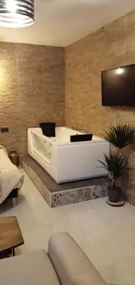 a large white tub in a room with a couch at ESTUDIO Jacuzzi SOL De JEREZ in Jerez de la Frontera