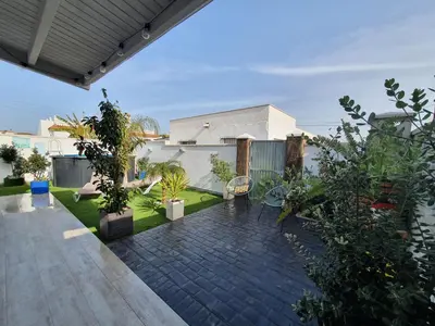 a kitchen and living room with a table and a television at EL ATARDECER in Conil de la Frontera