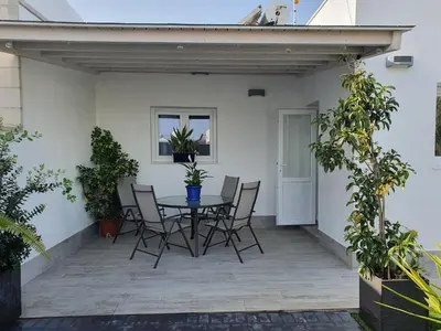 a living room with a couch and a table and chairs at EL ATARDECER in Conil de la Frontera