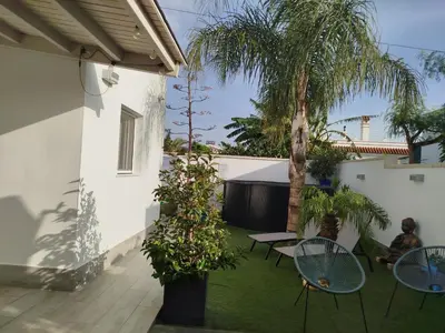 a small garden with chairs and a table at EL ATARDECER in Conil de la Frontera