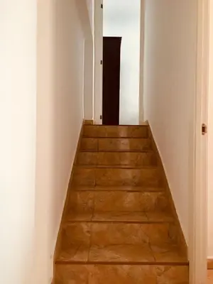 a stairway leading to a hallway with white walls and wooden floors at Apartamento sureño in Cádiz