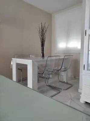 a dining room with a white table and chairs at Idalia 19 Atico in Sanlúcar de Barrameda