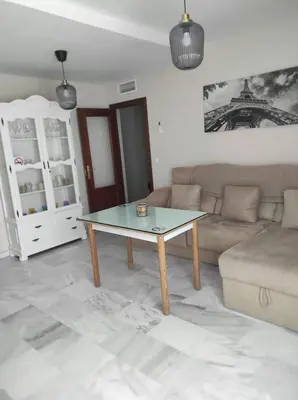 a living room with a couch and a table at Idalia 19 Atico in Sanlúcar de Barrameda
