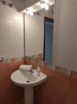 a bathroom with a white sink and a mirror at Idalia 19 Atico in Sanlúcar de Barrameda