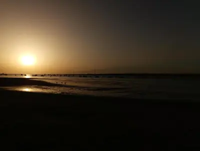 a sunset on the beach with the sun setting at Idalia 19 Atico in Sanlúcar de Barrameda