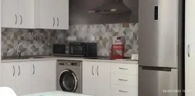 a kitchen with a refrigerator and a washing machine at Chipiona Santuario de Regla Playa Bajo A in Chipiona
