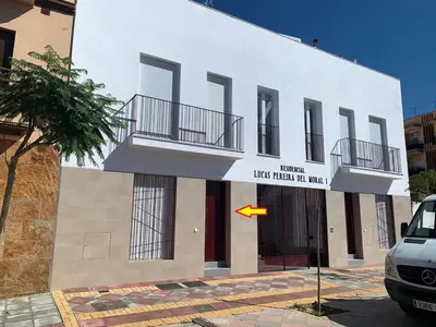 a white building with a yellow flag in front of it at Chipiona Santuario de Regla Playa Bajo A in Chipiona