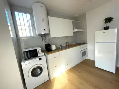 a kitchen with a washing machine and a refrigerator at El Ático de Botica in Cádiz