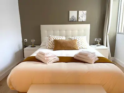 a bedroom with a large white bed with towels on it at El Ático de Botica in Cádiz