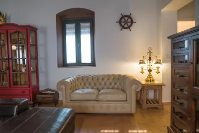 a living room with a couch and a red cabinet at Loft en casa Palacio Mergelina Parking gratis in Sanlúcar de Barrameda