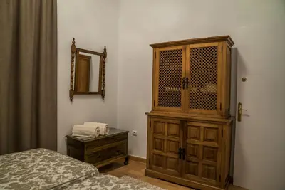 a bedroom with a dresser and a wooden cabinet at Loft en casa Palacio Mergelina Parking gratis in Sanlúcar de Barrameda