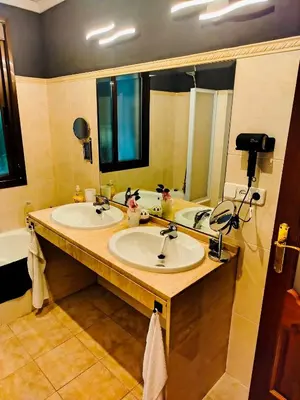 a bathroom with two sinks and a large mirror at The Magic House in El Puerto de Santa María