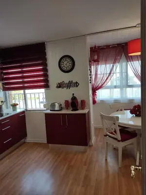 a kitchen with a table and a clock on the wall at Caprichos in Jerez de la Frontera