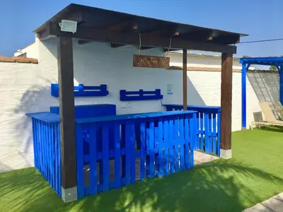 a blue pergola with blue benches in a yard at EL ALAZAN in Chiclana de la Frontera