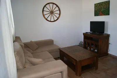 a living room with a couch and a tv at EL ALAZAN in Chiclana de la Frontera