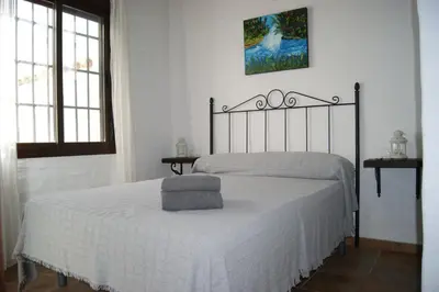 a bedroom with a bed with a white bedspread at EL ALAZAN in Chiclana de la Frontera