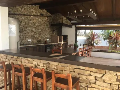 a bar with wooden chairs and a stone wall at EL ALAZAN in Chiclana de la Frontera