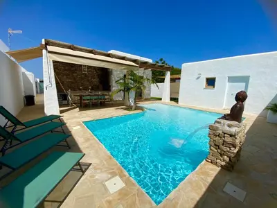 a swimming pool in front of a house with a patio at TURQUETA in Chiclana de la Frontera
