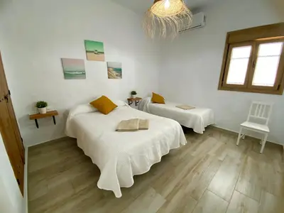 a room with two beds and a chair in it at TURQUETA in Chiclana de la Frontera