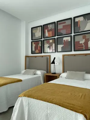 two beds in a room with pictures on the wall at LyriosHomes Luxury Costa Ballena Beach in Chipiona