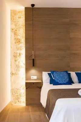 a bedroom with a bed and a wooden wall at La Terraza del Populo Little Apartments in Cádiz