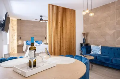 a living room with a table and a blue couch at La Terraza del Populo Little Apartments in Cádiz