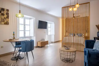 a living room with a table and blue chairs at La Terraza del Populo Little Apartments in Cádiz