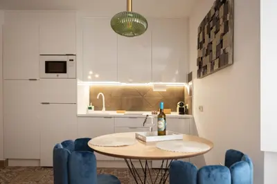 a kitchen with a table and some blue chairs at La Terraza del Populo Little Apartments in Cádiz
