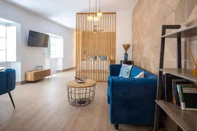 a living room with a blue couch and a table at La Terraza del Populo Little Apartments in Cádiz