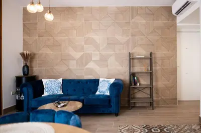 a living room with a blue couch and a wall at La Terraza del Populo Little Apartments in Cádiz