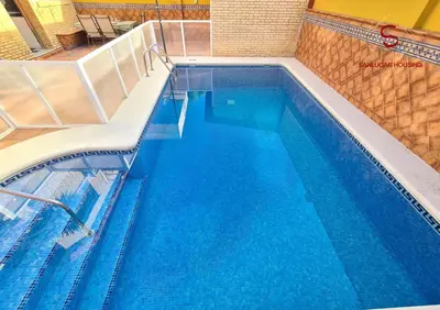 a large swimming pool with blue water at Casa Hermosilla con piscina by Sanlúcar Housing in Sanlúcar de Barrameda