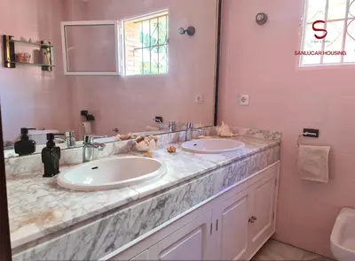 a bathroom with two sinks and a mirror at Casa Hermosilla con piscina by Sanlúcar Housing in Sanlúcar de Barrameda