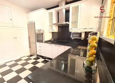 a kitchen with white cabinets and a black and white checkered floor at Casa Hermosilla con piscina by Sanlúcar Housing in Sanlúcar de Barrameda