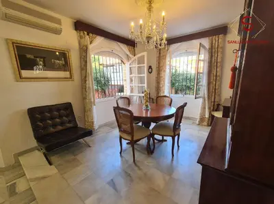 a dining room with a table and chairs and a chandelier at Casa Hermosilla con piscina by Sanlúcar Housing in Sanlúcar de Barrameda