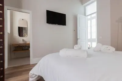 a white bedroom with a bed with towels on it at Casa Mariana - Luxury Apartment - 4 Personas in Cádiz